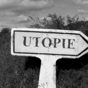 Das Bild zeigt ein pfeilförmiges Schild mit der Aufschrift Utopie
