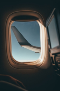 Blick aus einem Flugzeugfenster auf den linken Flügel und die Landeklappen.