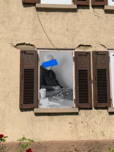 Collage: Fenster und darin ein schwarz-weißes Bild eines Rentners, der ein Brettspiel spielt
